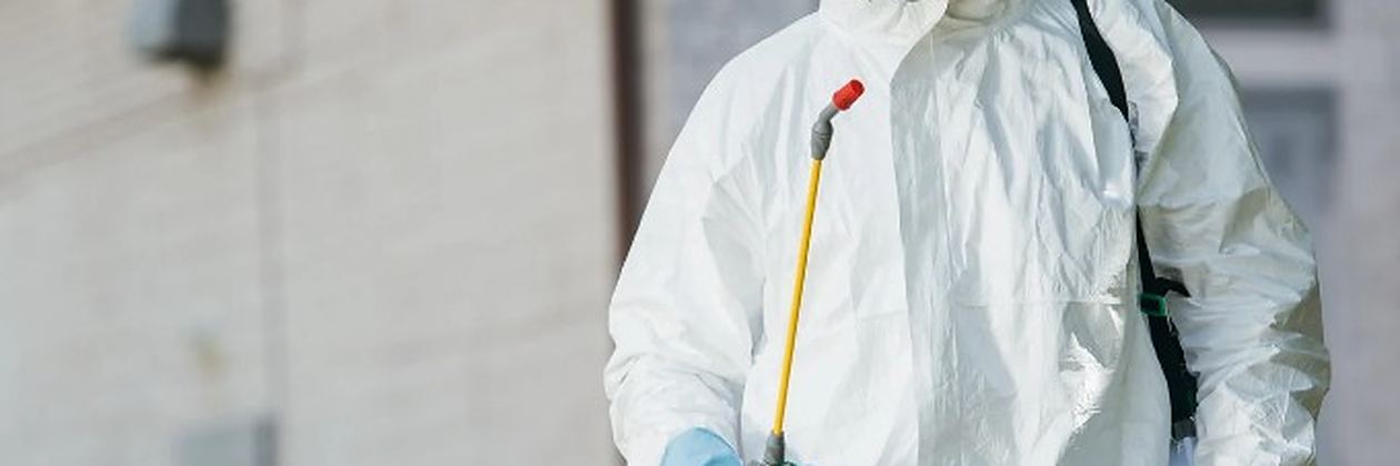 Técnico con máquina de nebulización generando humo insecticida junto a una zona ajardinada en un servicio de control de plagas en Valverde de la Virgen Técnico con máquina de nebulización generando humo insecticida junto a una zona ajardinada en un servicio de control de plagas en Valverde de la Virgen